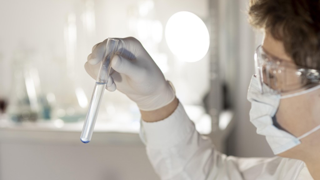 Scientist holds test tube with clear liquid