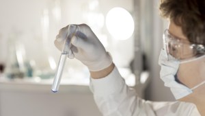 Scientist holds test tube with clear liquid