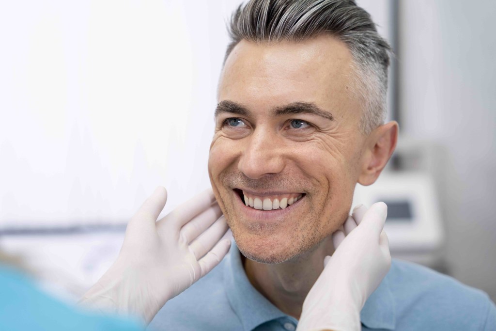 Male patient smiling at doctor out of frame