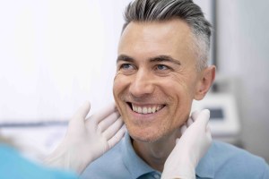Male patient smiling at doctor out of frame